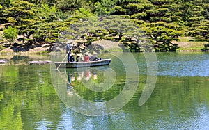 Poling a Boat Across a Pond in a Japanese Garden