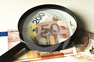 Polish banknotes and the banknote euro under the magnifying glass.