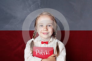 Polish concept with little girl student with book