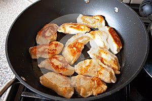 Polish dish pirogi in frying pan. Preparing traditional polish meal pirogi. Food preparing conceptual images.