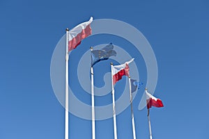 Polish and EU flags on sky background