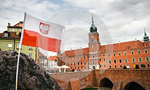 Polish flag in front of The Royal castle. Old town in Warsaw.