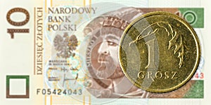 1 polish groszy coin against 10 polish zloty bank note