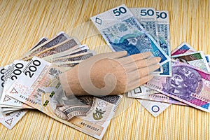Polish money covered with a wooden hand