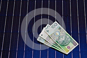 Polish money on solar panel surface. Renewable energy cost
