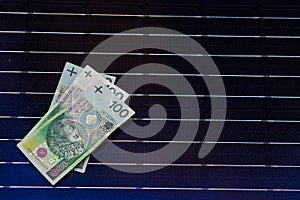 Polish money on solar panel surface. Renewable energy cost