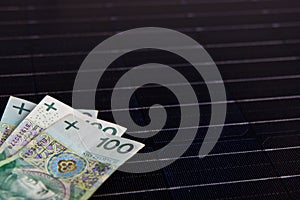 Polish money on solar panel surface. Renewable energy cost