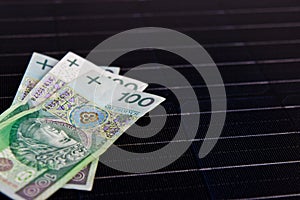 Polish money on solar panel surface. Renewable energy cost photo