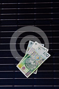 Polish money on solar panel surface. Renewable energy cost photo