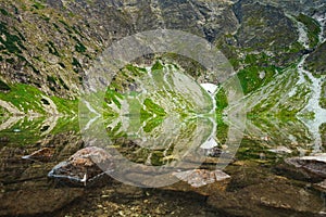 Polish Tatra Mountains, Czarny Staw, view from the trail and the shore of a pond with clear water at the foot of the mountain