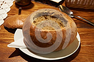 Polish traditional soup Zurek in bread, selective focus