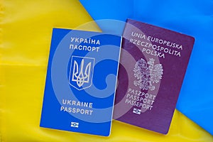 Polish and Ukrainian biometric passport on background of the national flag of Ukraine