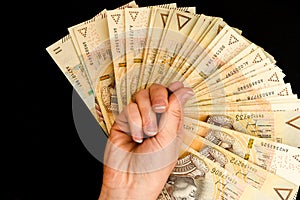 Polish zloty currency, hand holding polish zloty cash on the black background