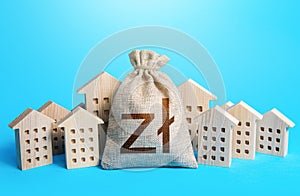 Polish zloty money bag among town houses figurines. Municipal budgeting. Rental business. Realtor services. Property taxes. Tax