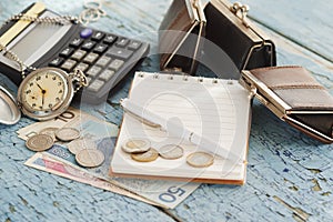 Polish zloty, wallets, pocket clock, notebook and calculator, wooden background