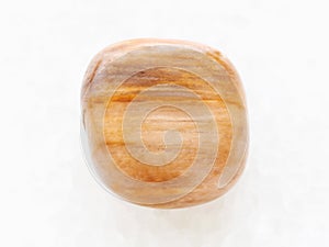 polished brown tiger's eye gem on white marble