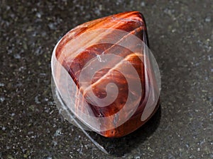 polished Bull's Eye gemstone on dark background