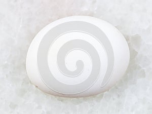 polished cacholong (white opal) gemstone on white photo
