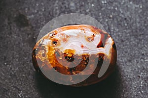 Polished carnelian gemstone on a black background