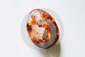 Polished carnelian gemstone on a white background