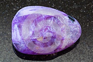 Polished Charoite gem on dark background