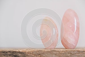 Polished crystals rose quartz gemstone on a wooden table. Copy, empty space for text