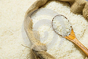 Polished jasmine rice and wooden spoon in gunny sack