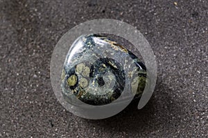 Polished kambaba jasper gemstone on a black background