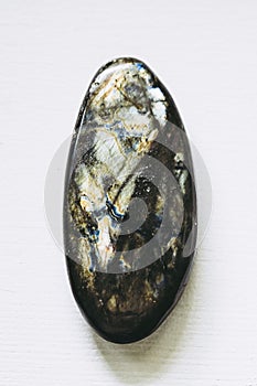 Polished labradorite gemstone on a white background