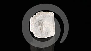 Polished mineral stone iceland spar rotates in a circle on a black background