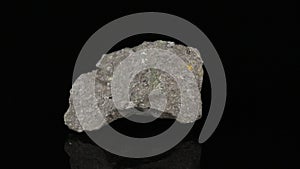 Polished mineral stone Olivine rotates in a circle on a black background