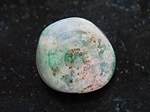 polished Moss Agate gemstone on dark