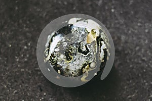 Polished ocean jasper gemstone on a black background photo