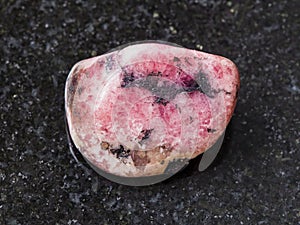 polished pink rhodonite gem stone on dark