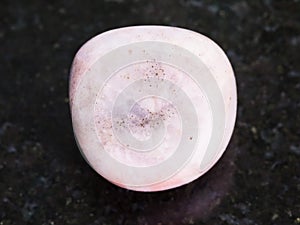 polished rhodonite gem stone on dark