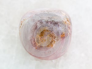 polished rhodonite gem stone on white marble