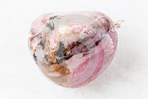 Polished Rhodonite rock on white marble