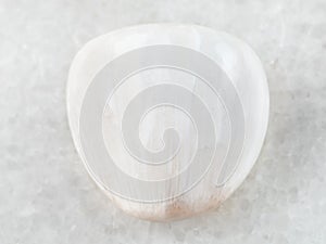 polished Scolecite gemstone on white marble photo