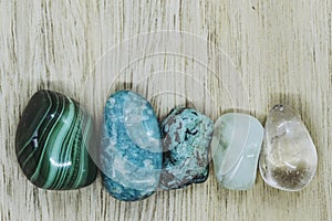 Polished stones malachite azurite turquoise aventurine rock crystal on a wooden background