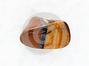 polished tiger eye gemstone on white marble