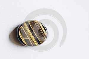 Polished tiger eye tumbled stone pebble on a white background with empty space