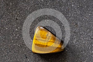 Polished tigereye gemstone on a black background