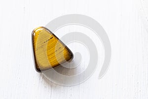 Polished tigereye gemstone on a white background