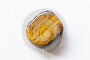 Polished tigereye gemstone on a white background