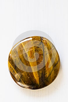 Polished tigereye gemstone on a white background