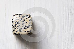 Polished tumbled dalmatien jasper stone on a white background