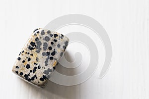 Polished tumbled dalmatien jasper stone on a white background