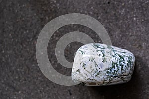 Polished tumbled stone tree agate on a black background