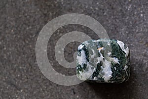 Polished tumbled stone tree agate on a black background