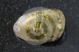 polished unakite gem stone on dark background